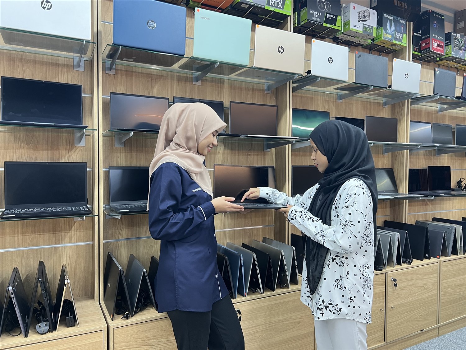 Mechanize team member helping a customer choose a laptop
